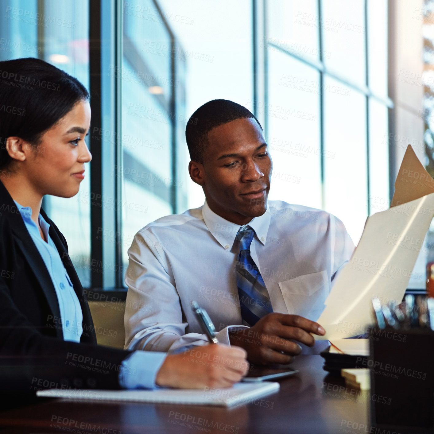 Buy stock photo Cropped shot of two young businesspeople meeting in the boardroom