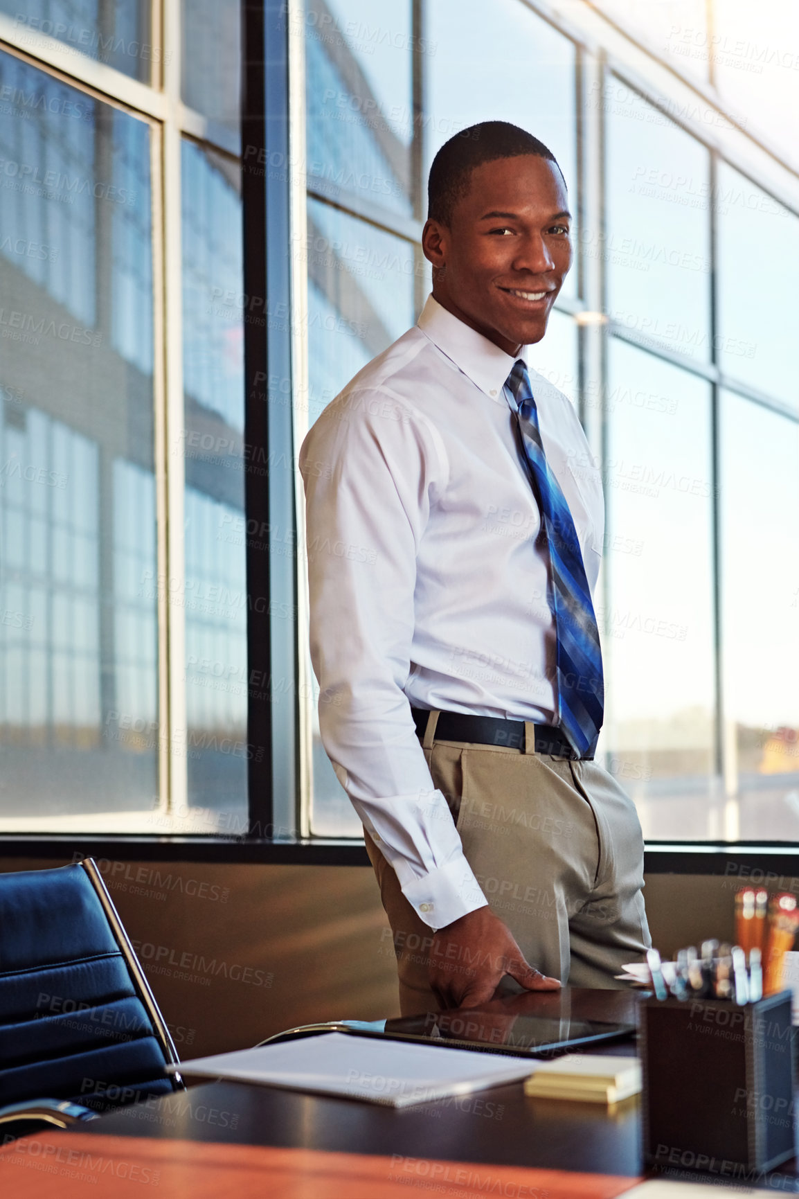 Buy stock photo Portrait of a young male lawyer standing by his desk in the office