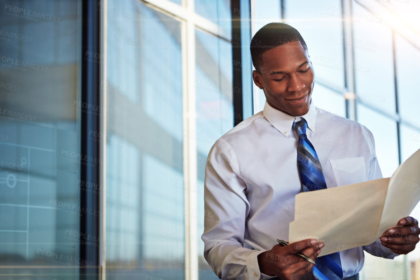 Buy stock photo Shot of a young male lawyer standing in his office