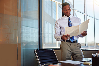 Buy stock photo Shot of a young male lawyer standing by his desk in the office