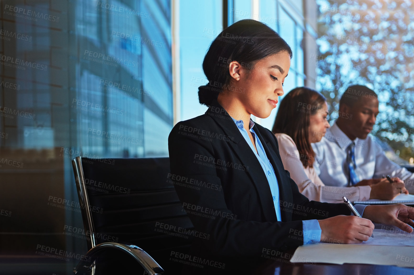 Buy stock photo Cropped shot of three young businesspeople meeting in the boardroom