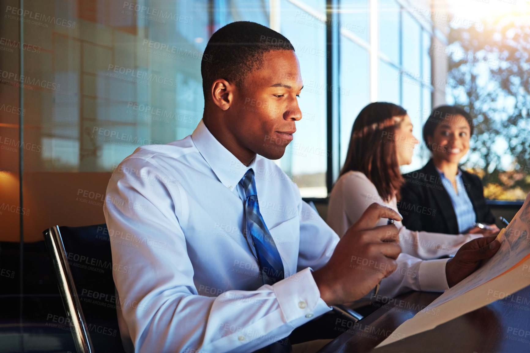 Buy stock photo Cropped shot of three young businesspeople meeting in the boardroom