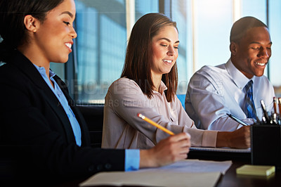 Buy stock photo Cropped shot of three young businesspeople meeting in the boardroom