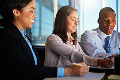 Buy stock photo Cropped shot of three young businesspeople meeting in the boardroom