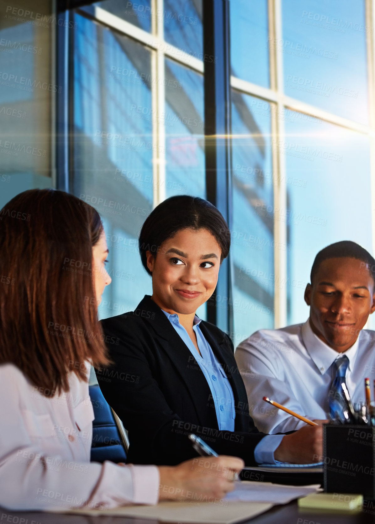 Buy stock photo Cropped shot of three young businesspeople meeting in the boardroom