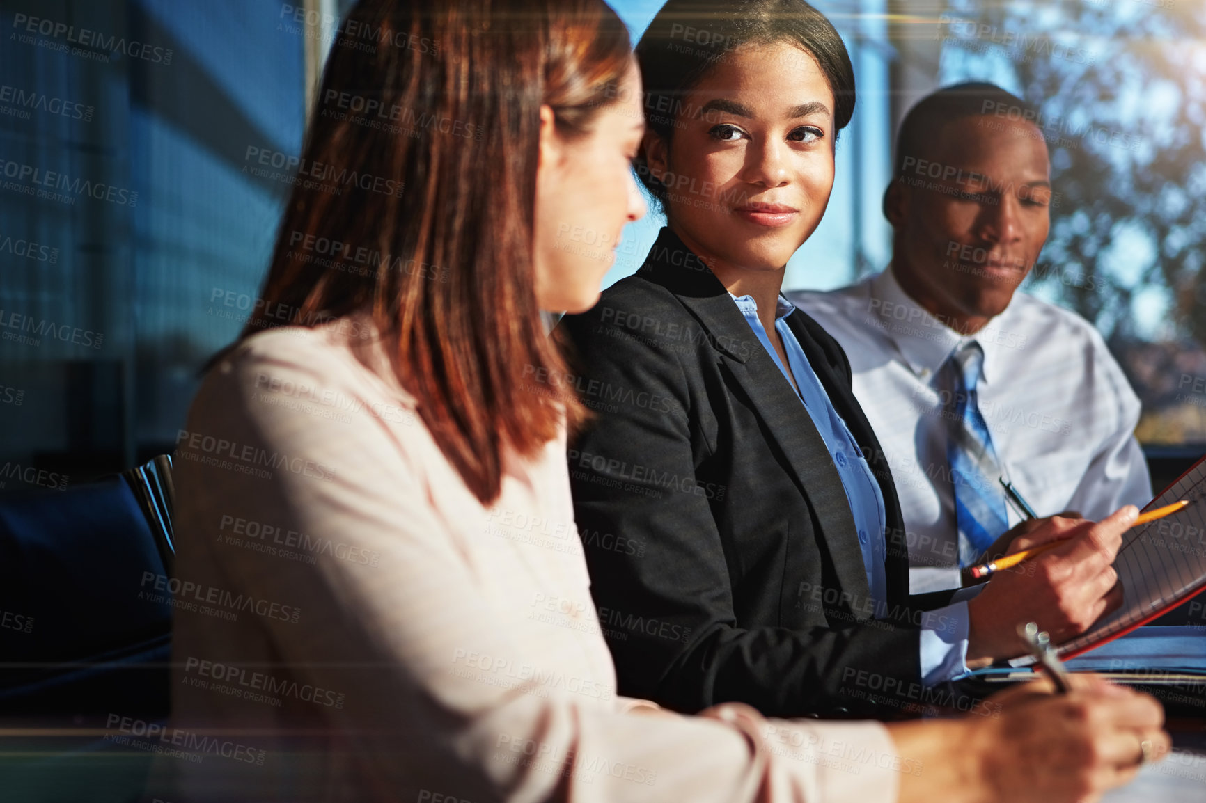 Buy stock photo Cropped shot of three young businesspeople meeting in the boardroom