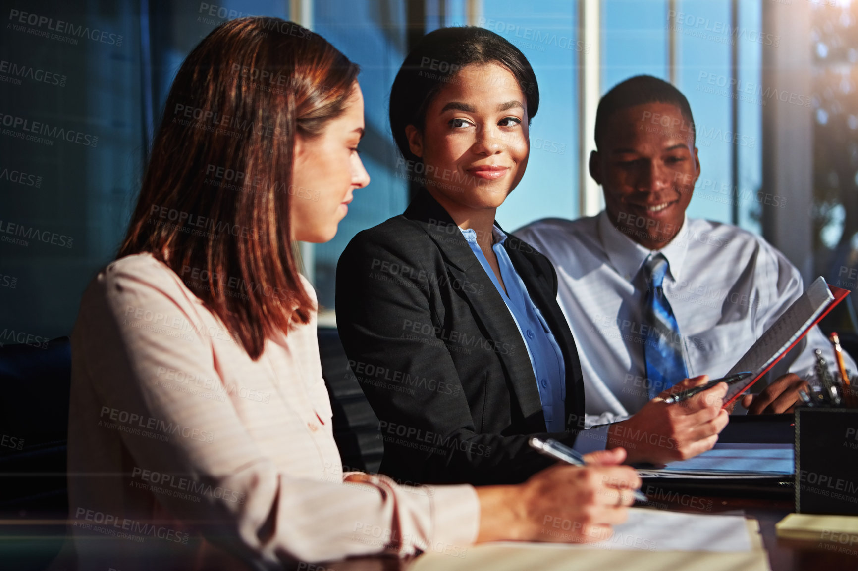 Buy stock photo Cropped shot of three young businesspeople meeting in the boardroom