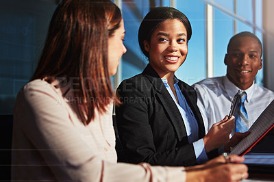 Buy stock photo Cropped shot of three young businesspeople meeting in the boardroom