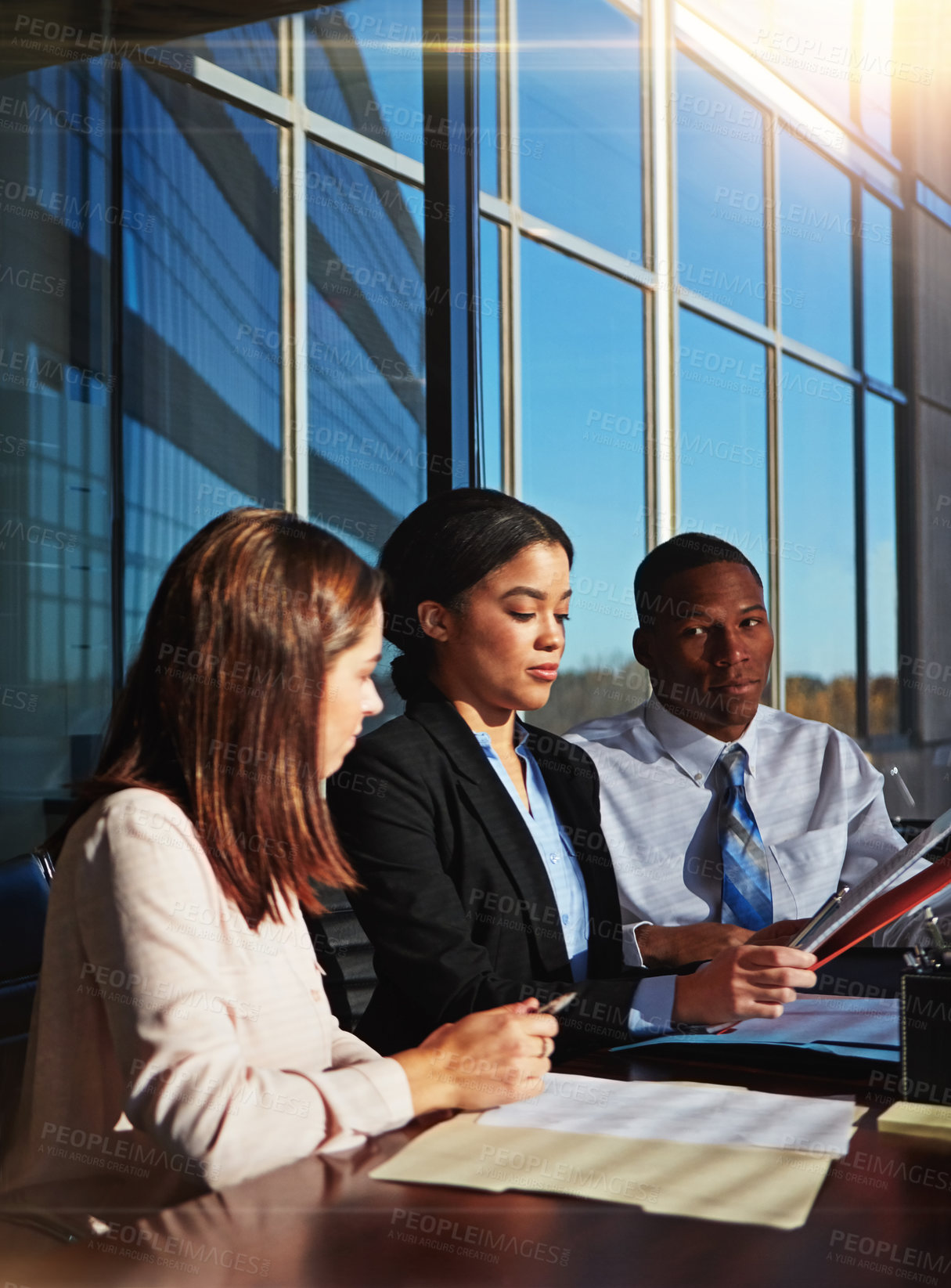 Buy stock photo Cropped shot of three young businesspeople meeting in the boardroom