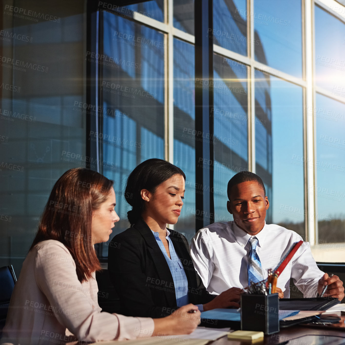 Buy stock photo Cropped shot of three young businesspeople meeting in the boardroom