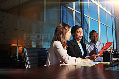 Buy stock photo Cropped shot of three young businesspeople meeting in the boardroom