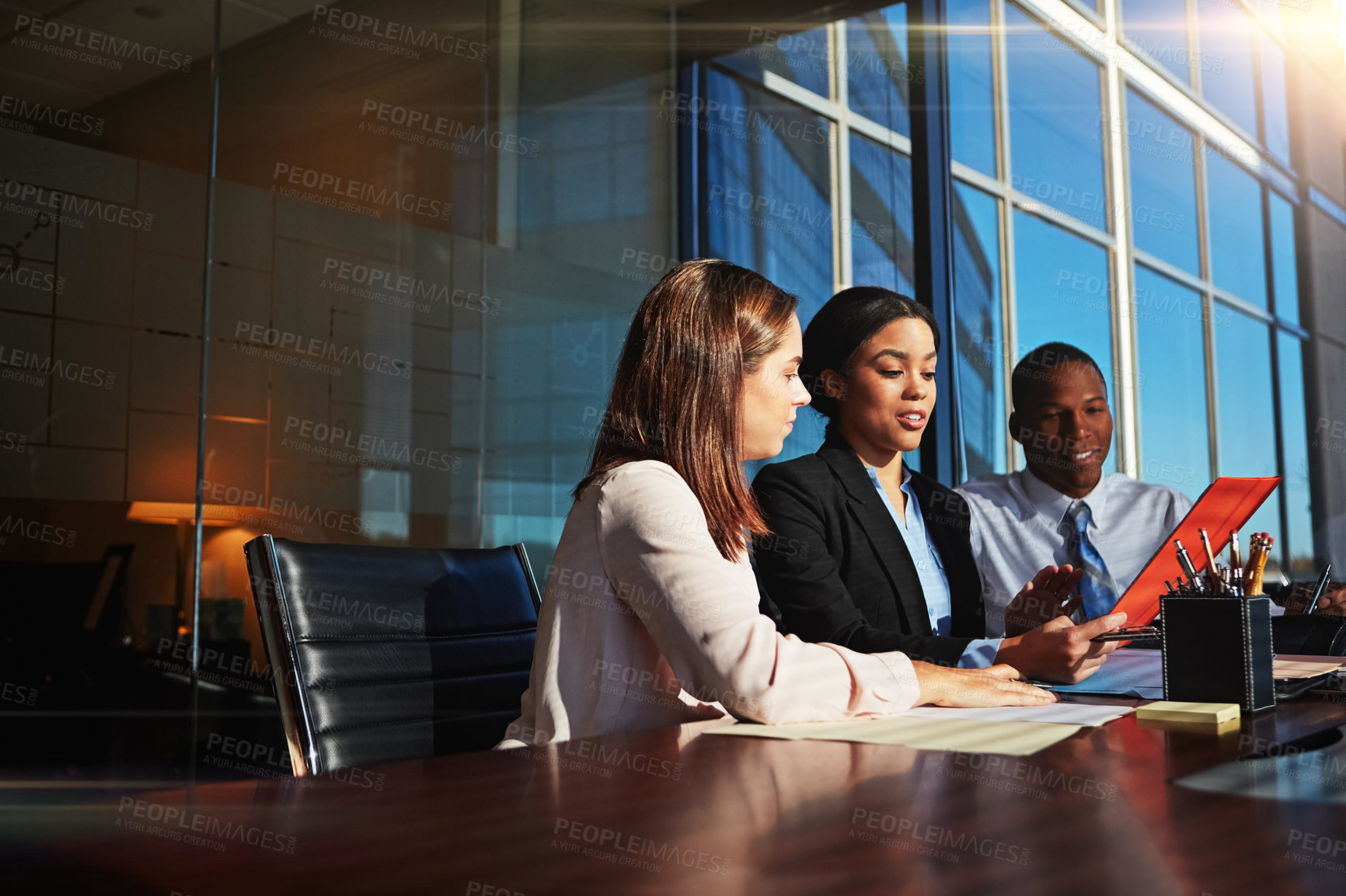 Buy stock photo Cropped shot of three young businesspeople meeting in the boardroom