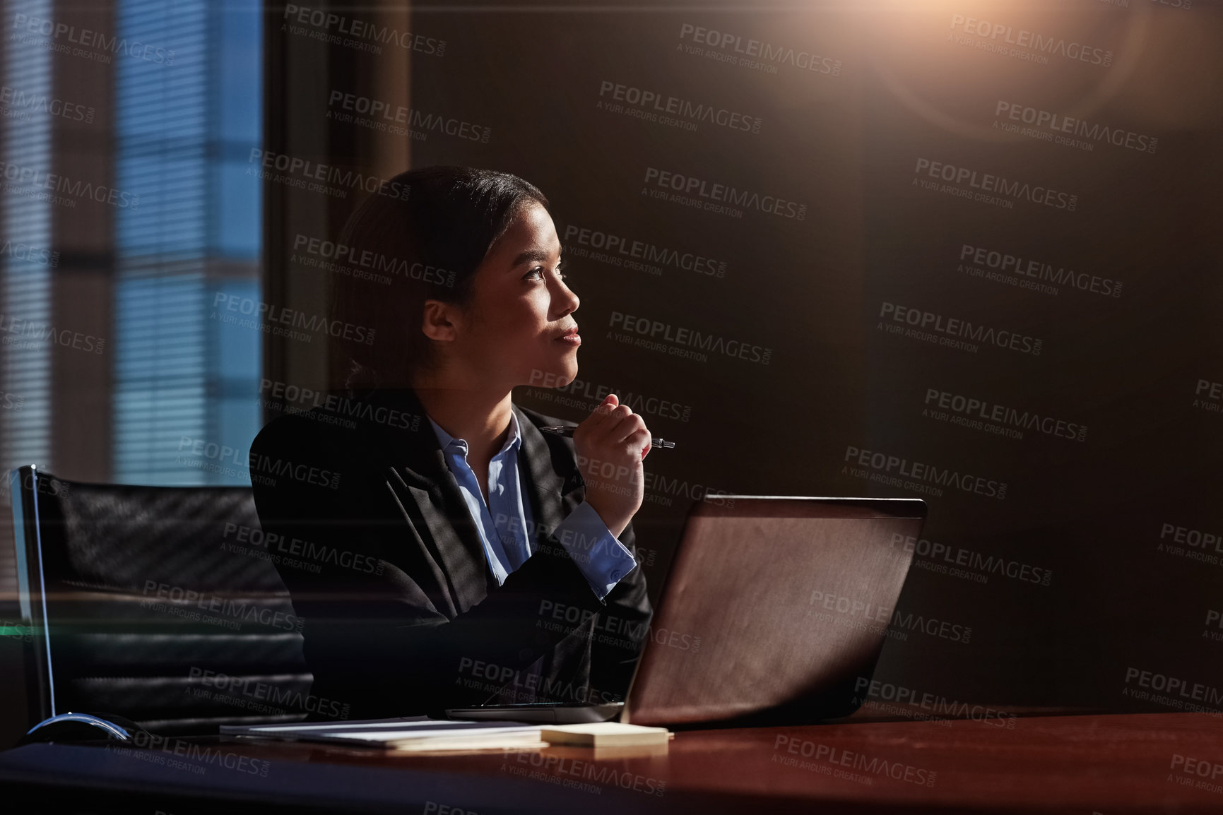 Buy stock photo Shot of a young woman contemplating while using her laptop