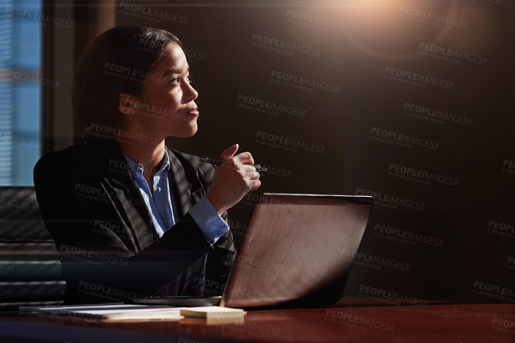 Buy stock photo Shot of a young woman contemplating while using her laptop