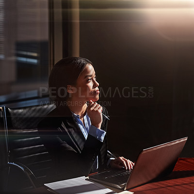 Buy stock photo Shot of a young woman contemplating while using her laptop