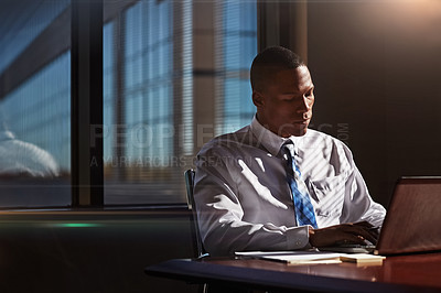 Buy stock photo Shot of a businessman using his laptop at his desk
