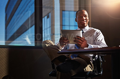 Buy stock photo Shot of a young man contemplating while using his digital tablet