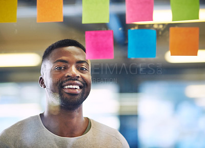 Buy stock photo Portrait of a young man having a brainstorming session with sticky notes at work