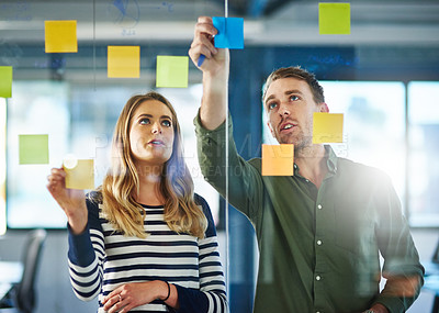 Buy stock photo Shot of colleagues having a brainstorming session with sticky notes at work