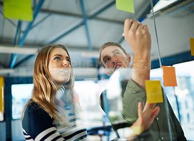 Buy stock photo Shot of colleagues having a brainstorming session with sticky notes at work