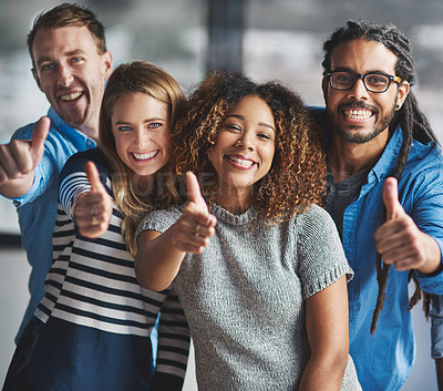 Buy stock photo Portrait of a group of creative businesspeople giving thumbs up while standing in their office