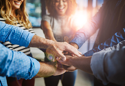 Buy stock photo Shot of a group of creative businesspeople standing with their hands in a huddle