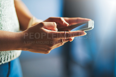 Buy stock photo Cropped shot of an unrecognizable businesswoman using her cellphone in the office