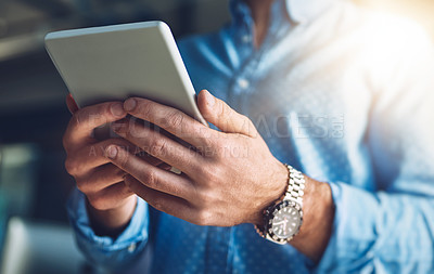 Buy stock photo Cropped shot of an unrecognizable young designer using his digital tablet in the office
