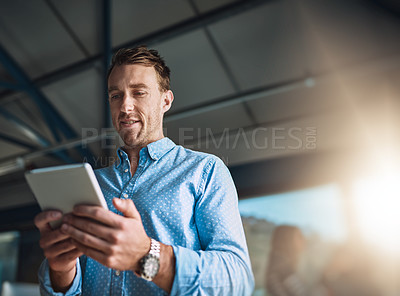 Buy stock photo Cropped shot of a handsome young designer using his digital tablet in the office