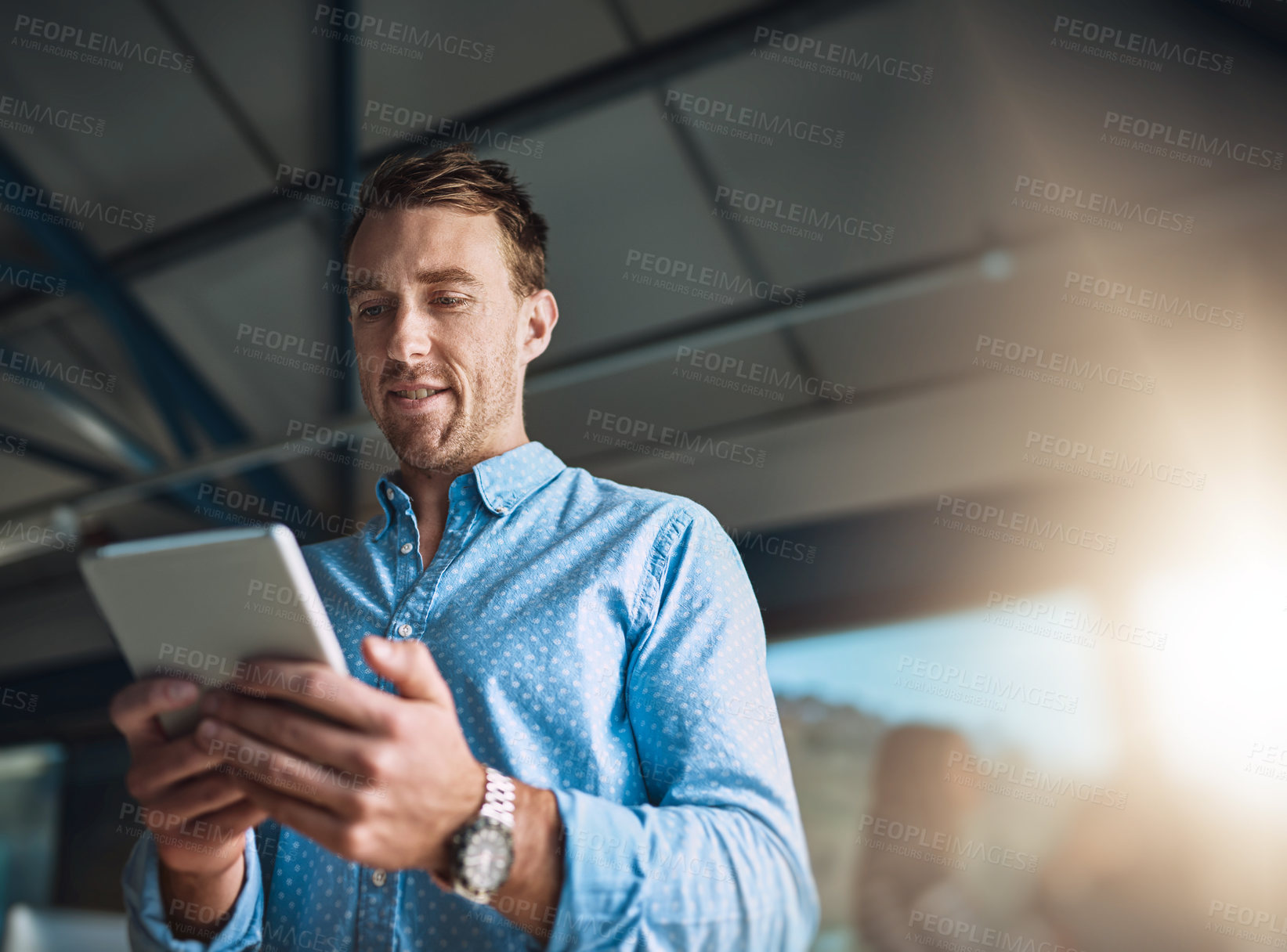 Buy stock photo Cropped shot of a handsome young designer using his digital tablet in the office