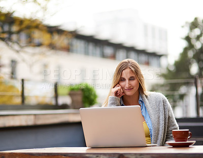 Buy stock photo Cropped shot of an attractive young woman using her laptop at an outdoor coffee shop