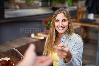 Buy stock photo Cropped shot of a young woman handing someone her credit card for payment in a cafe