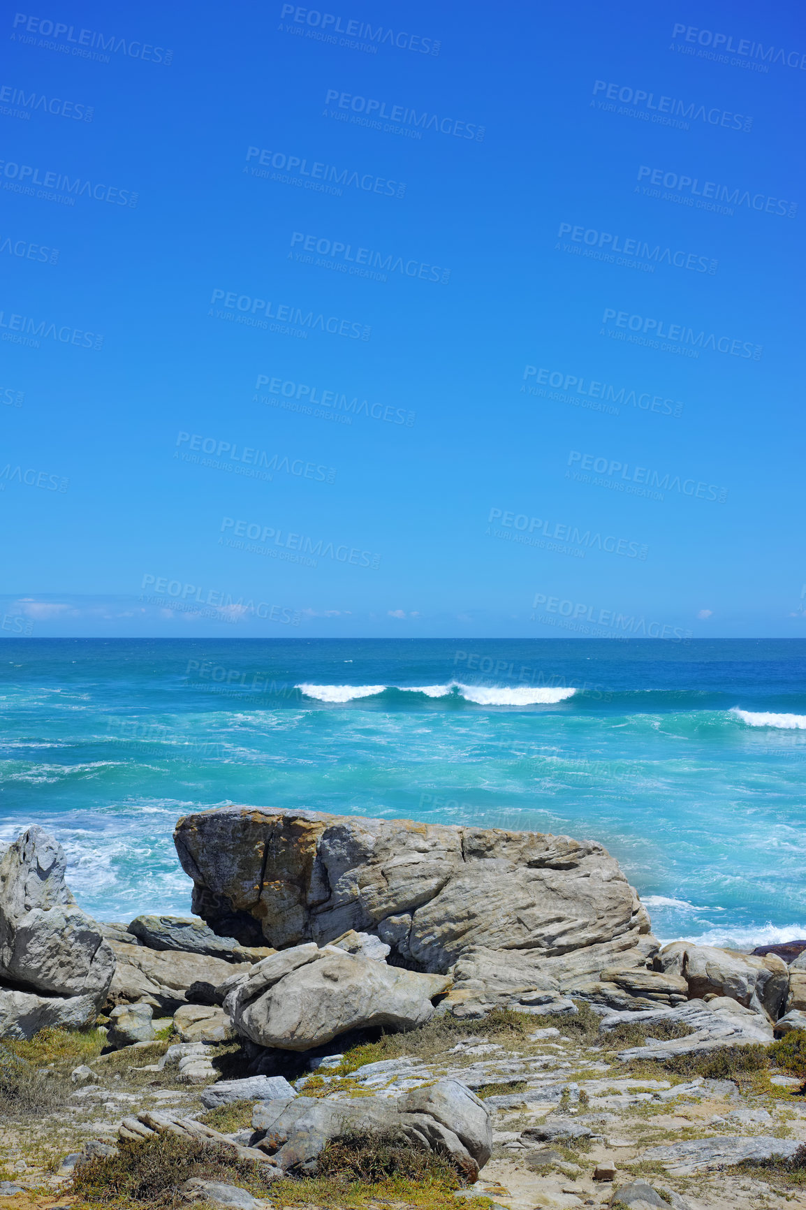 Buy stock photo Rocks, coast and ocean with waves, vacation and mockup space with blue sky, travel and Zanzibar. Empty, stones and outdoor with water, seaside and beach with shore, summer holiday and tropical island