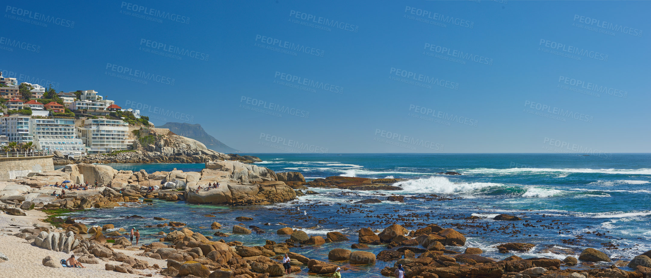 Buy stock photo Rocks, beach and ocean for travel, summer vacation or buildings in nature with mockup space on sky outdoor. Sea water, stones or waves in horizon with land for tourism, adventure and people on island