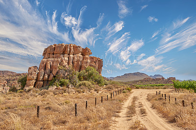 Buy stock photo Nature, road and sky with rock, formation and geology at location, bush or clouds in countryside. Countryside, stone and gravel path at conversation park, field or mountains with outcrop in Australia