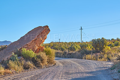 Buy stock photo Dirt road, rocks and landscape with nature, blue sky and adventure with tourism. Empty, travel and hills with Australia desert, ecology or plants with environment, clouds and sunshine with journey