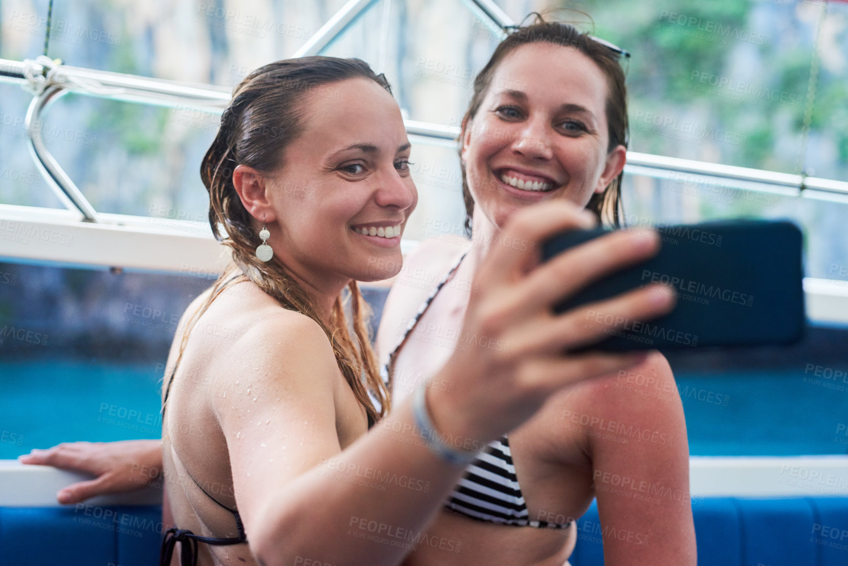 Buy stock photo Cropped shot of two young woman taking a selfie while on holiday