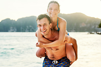 Buy stock photo Portrait of a young couple enjoying the day at the beach