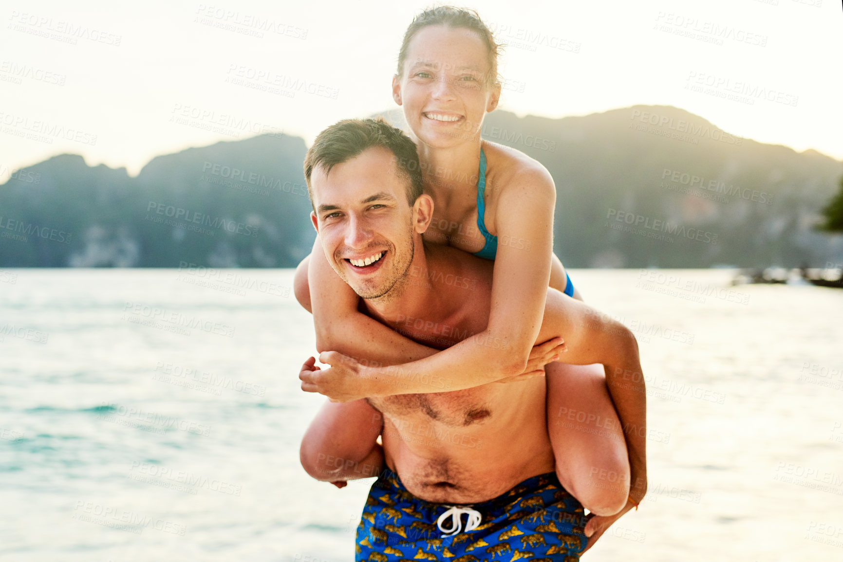 Buy stock photo Portrait of a young couple enjoying the day at the beach
