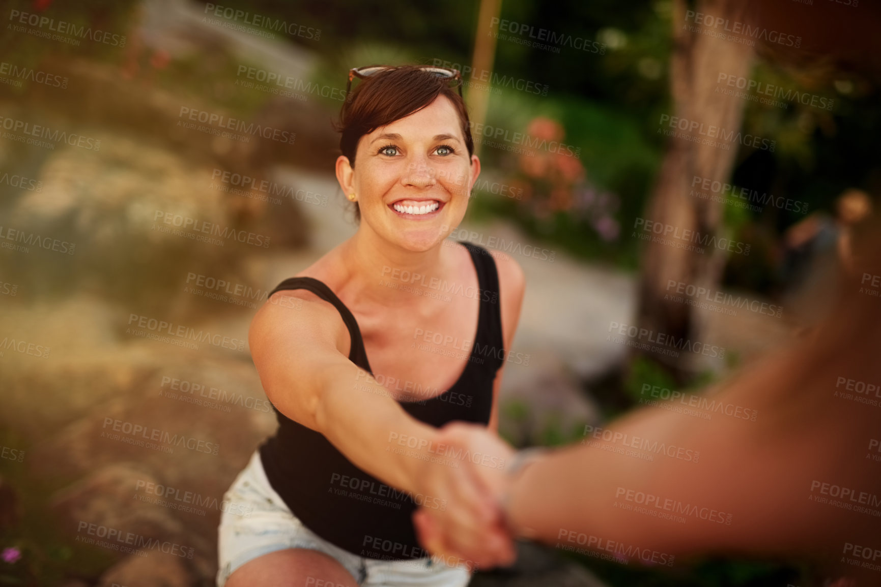 Buy stock photo Shot of a young woman being led by the hand while exploring outside
