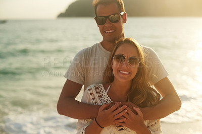 Buy stock photo Portrait of an affectionate young couple on the beach at sunset