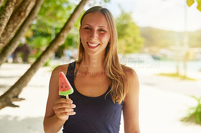 Buy stock photo Portrait of an attractive young woman enjoying a popsicle on the beach