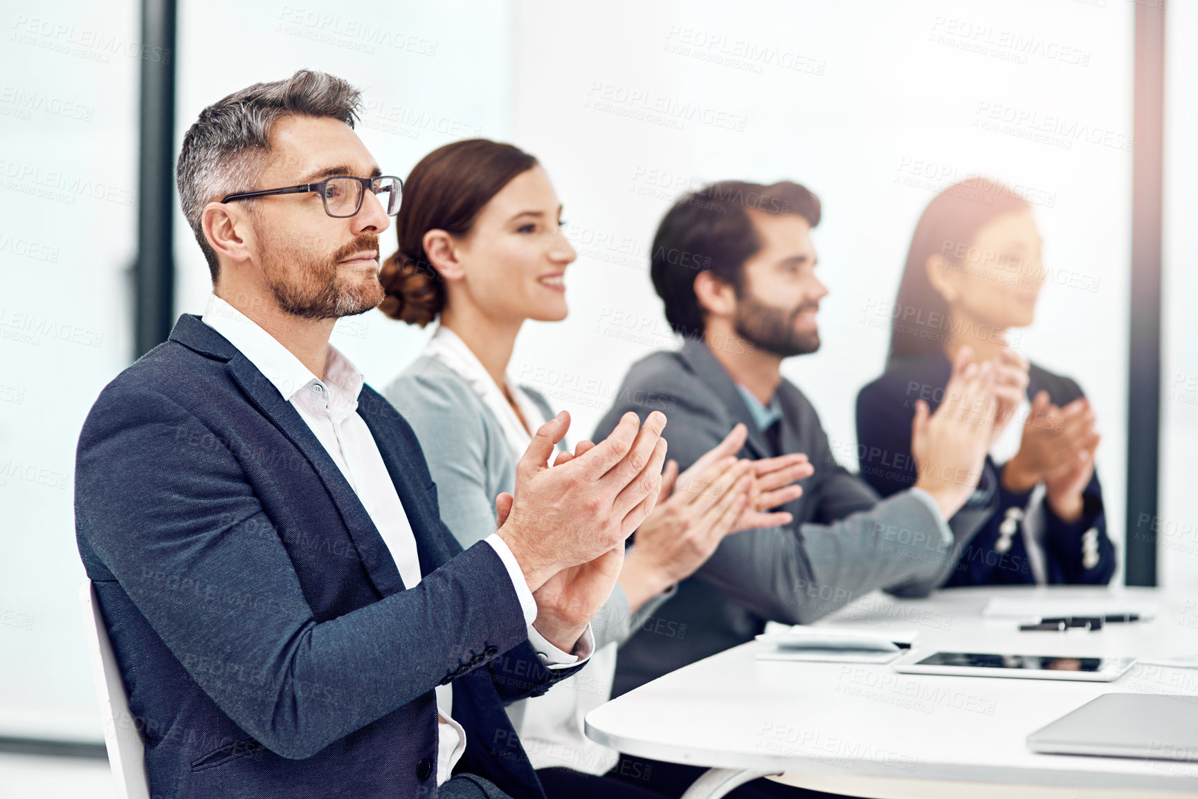 Buy stock photo Shot of a group of businesspeople applauding while sitting in the boardroom
