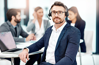 Buy stock photo Portrait of a male telephone operator in the office with his colleagues in the background