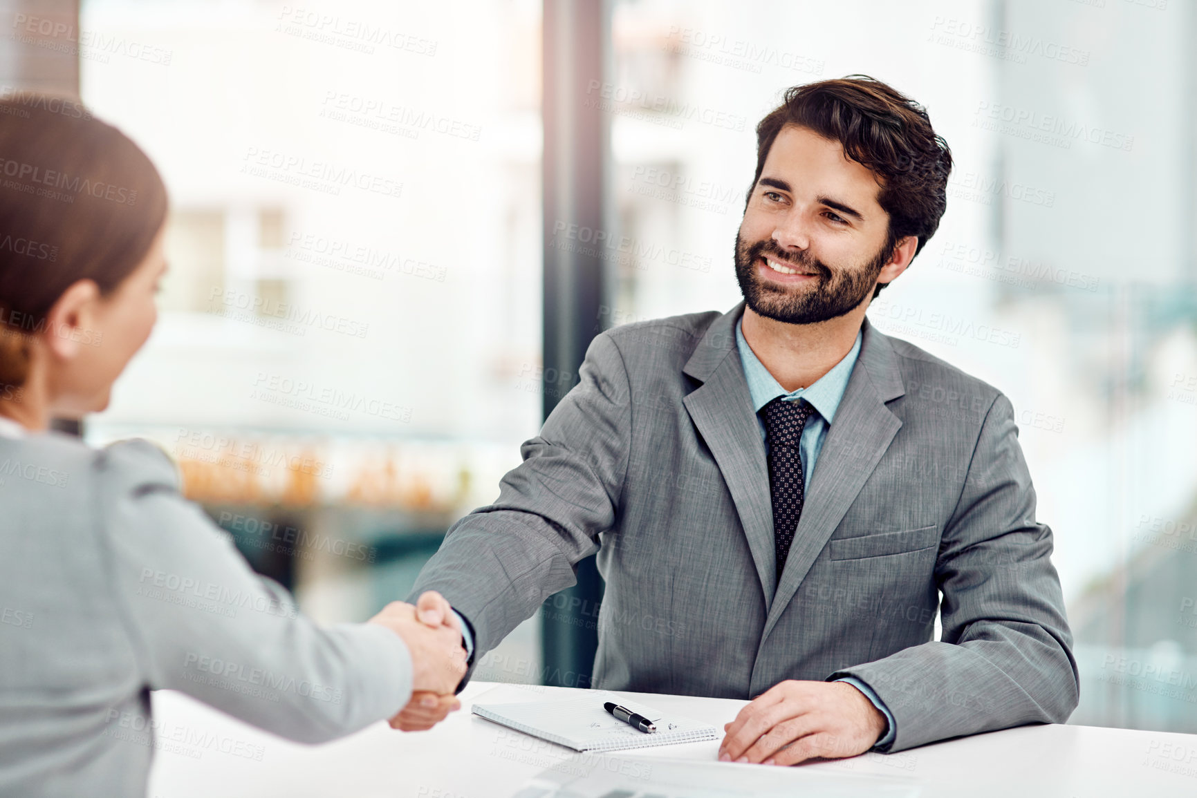 Buy stock photo Cropped shot of two businesspeople shaking hands in the office