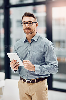 Buy stock photo Portrait of a handsome businessman using his tablet in the office