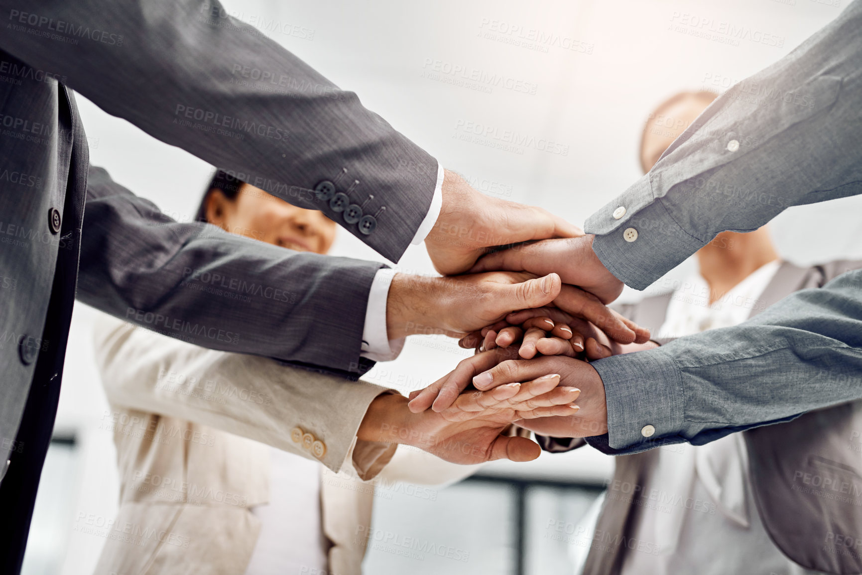 Buy stock photo Low angle shot of a group of businesspeople standing with their hands in a huddle