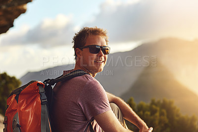 Buy stock photo Shot of a young man admiring the view from the top of a mountain