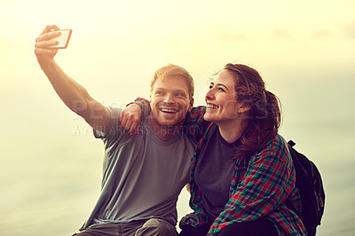 Buy stock photo Cropped shot of a young couple taking a selfie on a mountain top