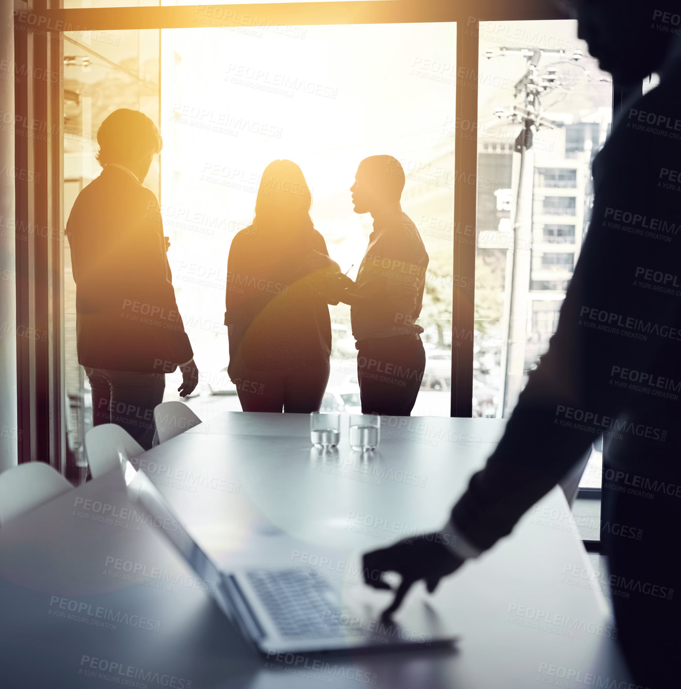 Buy stock photo Planning strategy for a successful and bright future with a team of business people talking in a boardroom meeting with flare. Backlit group of corporate professionals discussing in the office